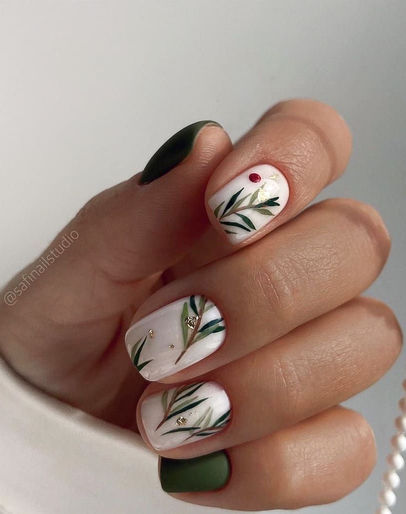 image of a hand with white nails with mistletoe art and gold accents