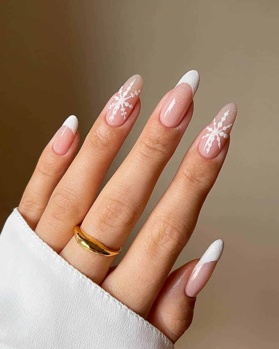 image of a hand with nude nails with a dainty white snowflake design