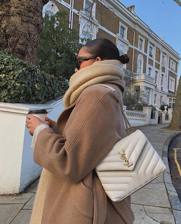 image of a woman in a wool coat, chunky scarf, carrying a YSL bag