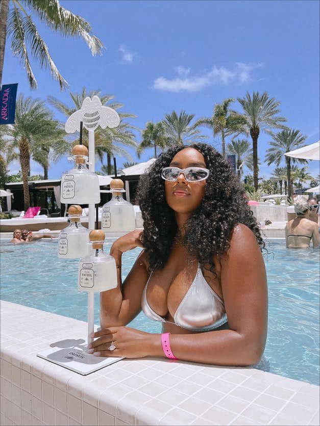 image of a black woman in a pool in Vegas wearing a metallic silver bikini top