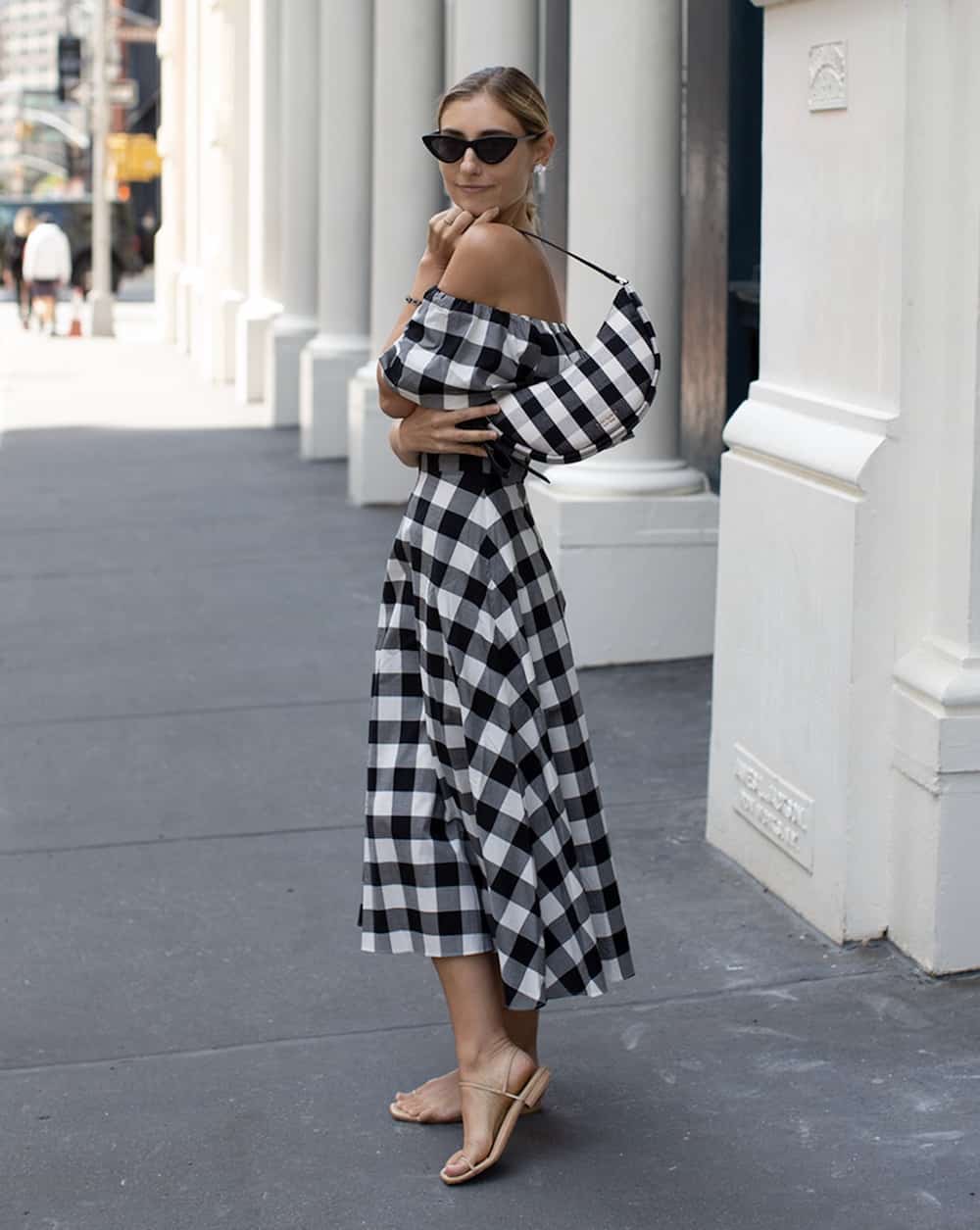 woman wearing a black and white gingham checkered dress and matching bag
