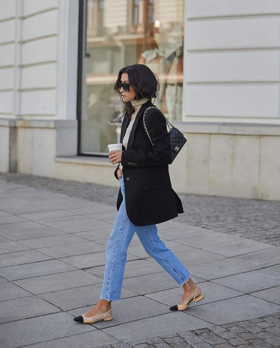 Woman wearing a black blazer with blue jeans and beige Chanel slingback flats