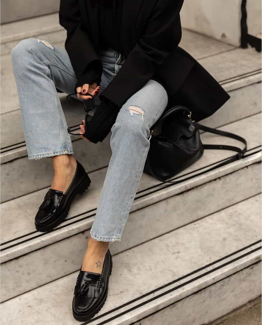 image of a woman in jeans and shiny black loafers 