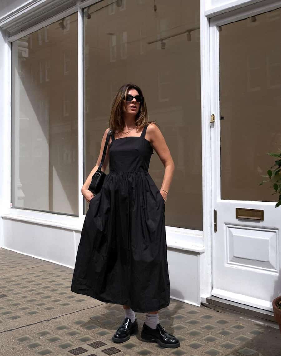 image of a woman in a cotton black midi dress with white ankle socks and black loafers