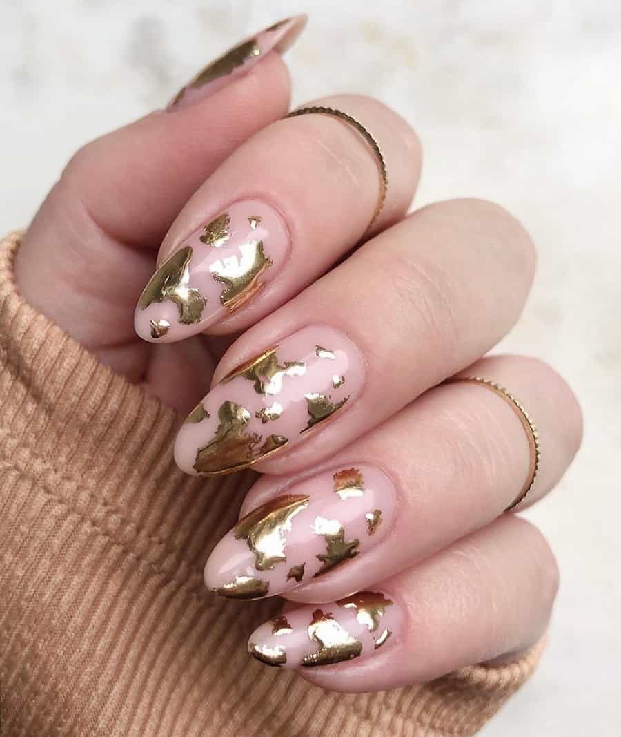 nude nails with a molten gold cow print design