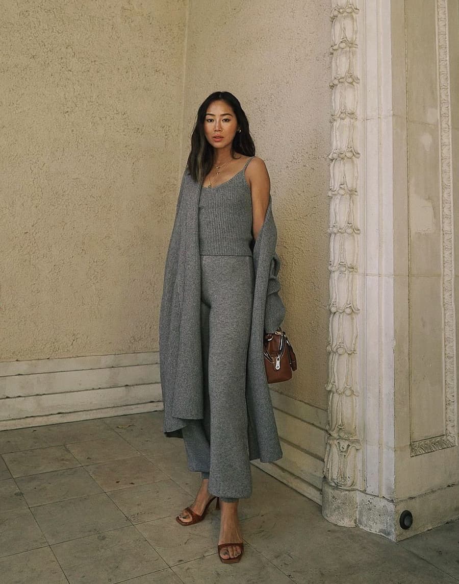 image of a woman wearing a grey knit matching camisole and pant set with a grey knit long cardigan