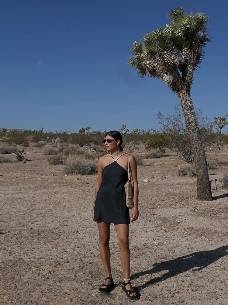 woman wearing a mini black slip dress in the desert