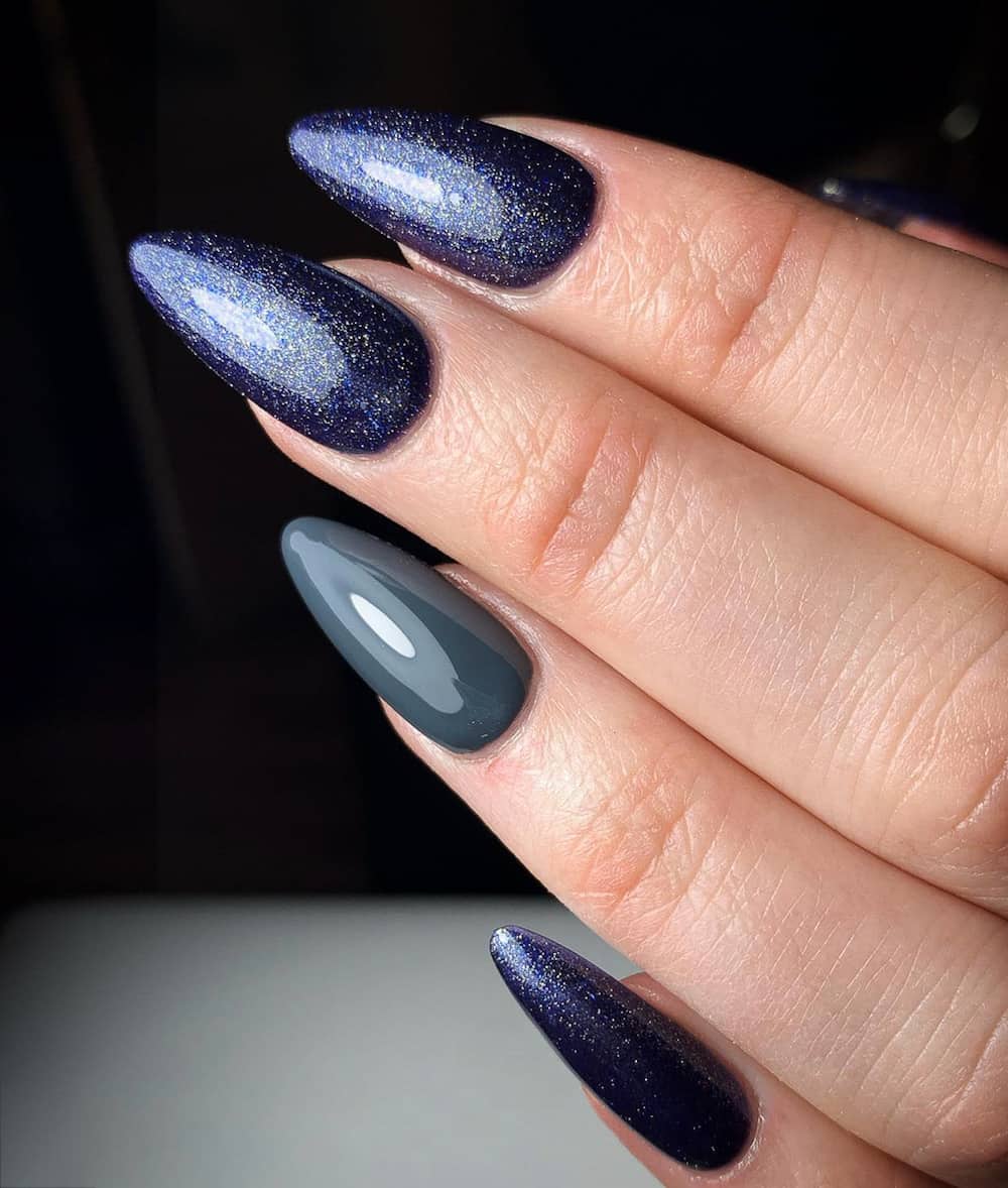 hand with pointed long glittery navy nails