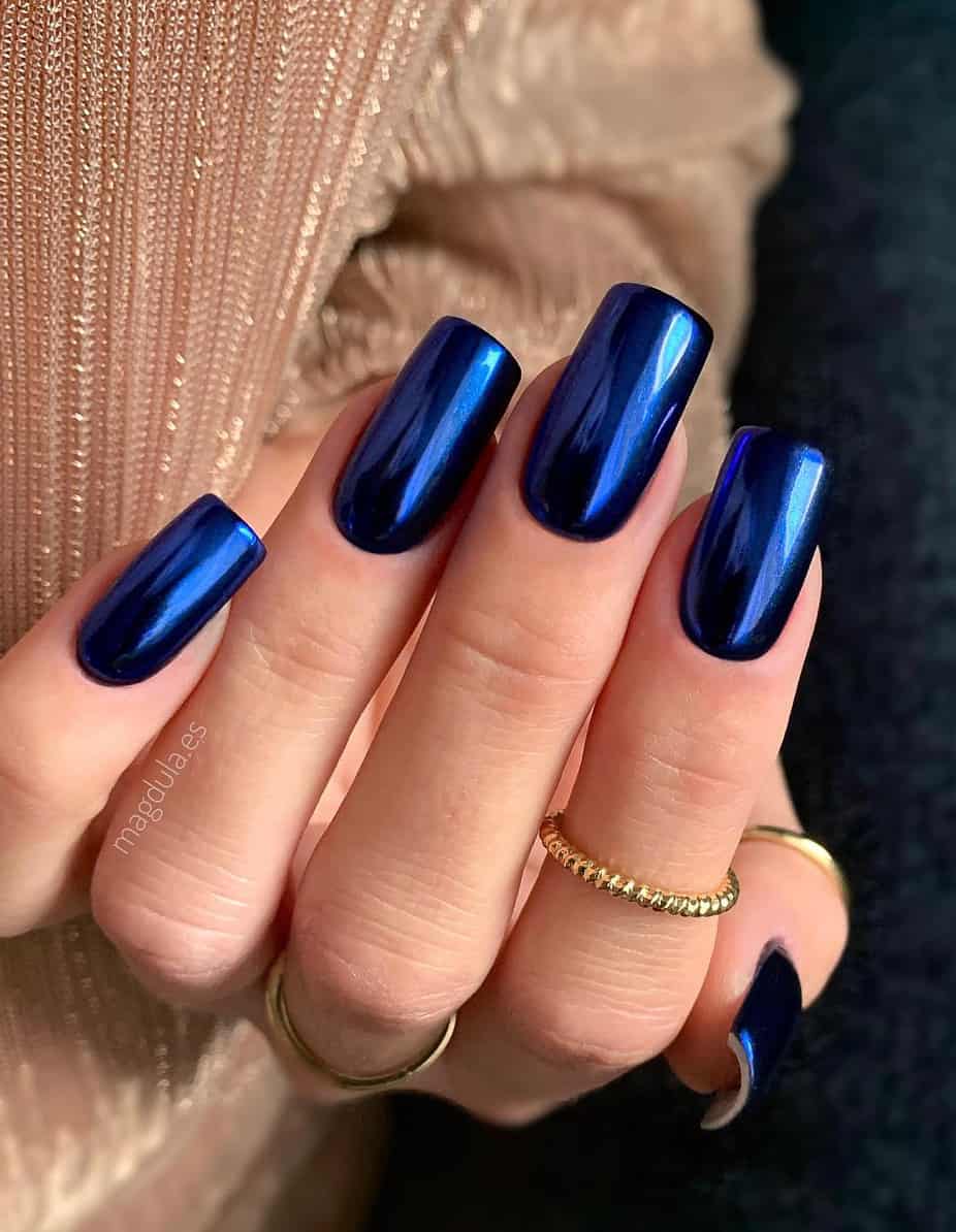 hand with dark metallic blue long square nails