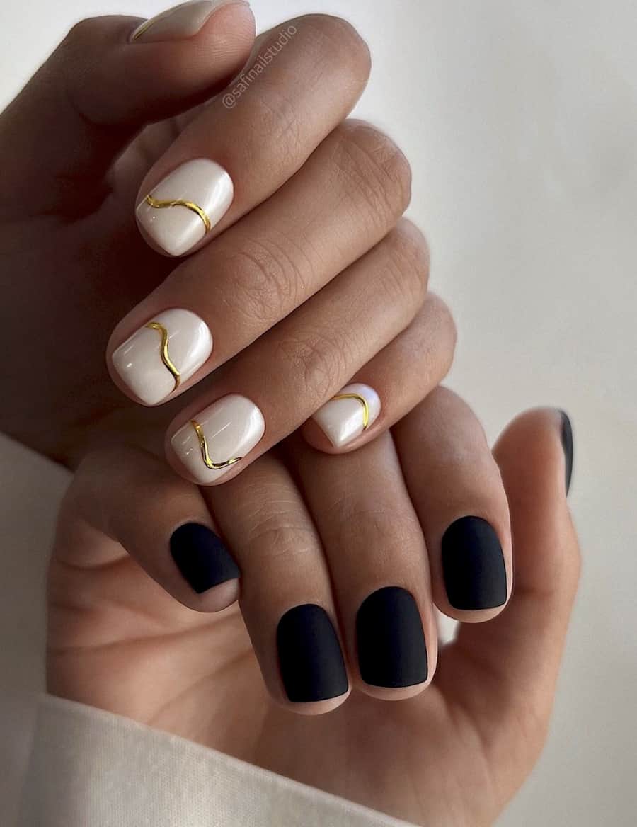 image of two hands with a gorgeous solar eclipse black and white nail design