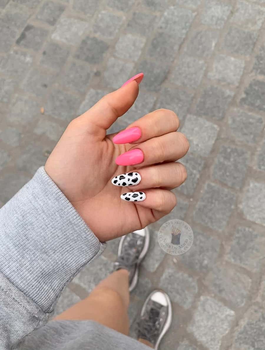 image of a hand with neon pink nails with minimal cow print accents