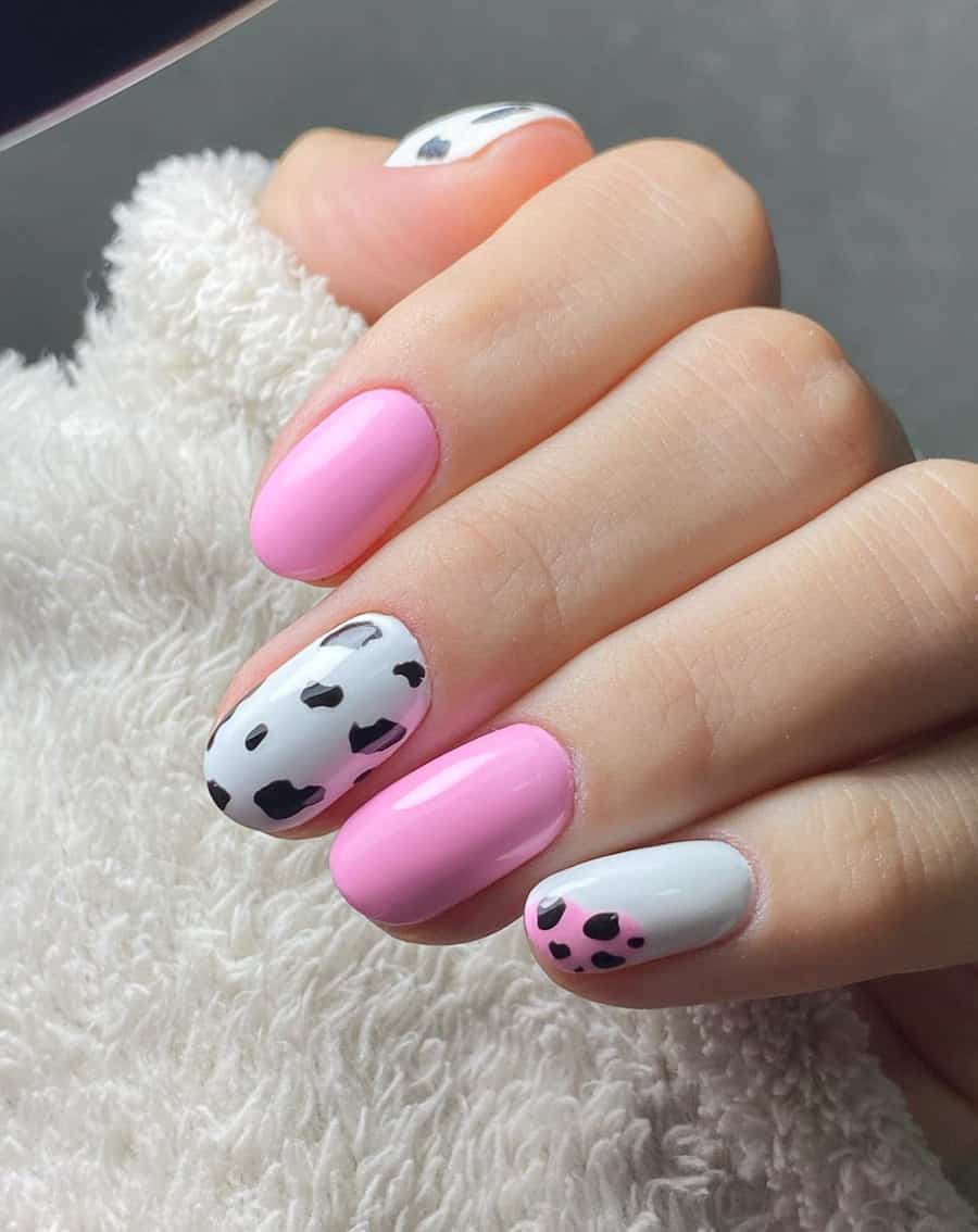 bubblegum pink nails with a white and black accent nail with a cow print design