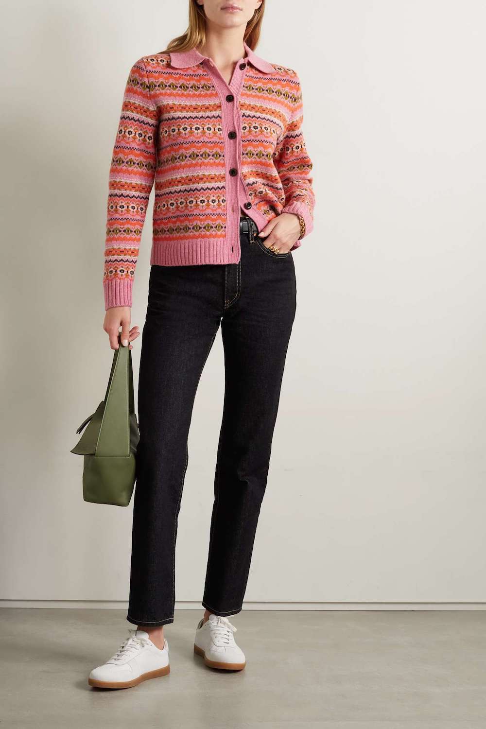 woman wearing an embroidered pink cardigan with black jeans