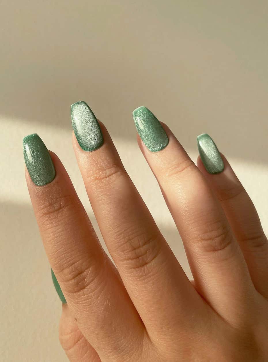 hand with cat eye sage green nail polish