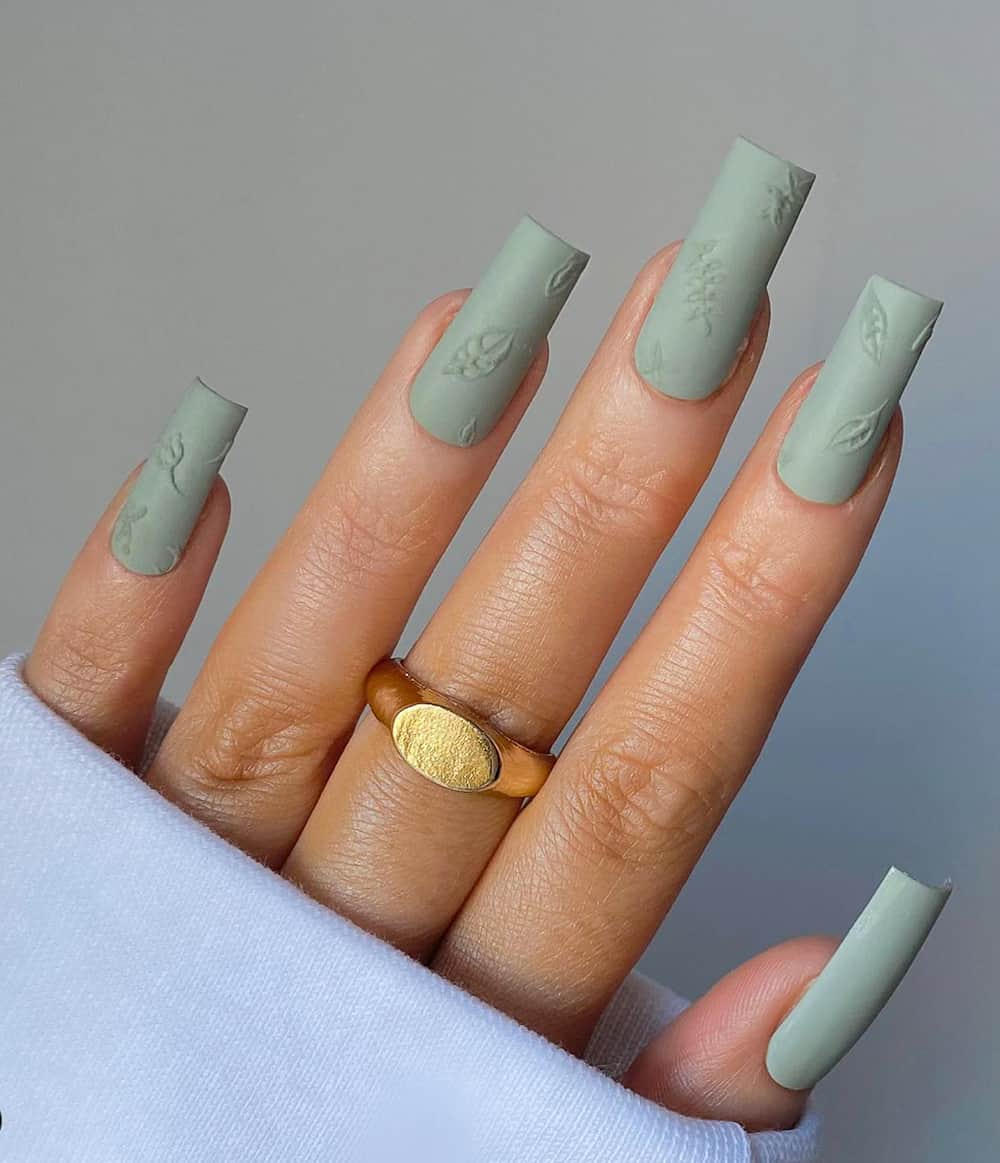 hand with long square matte sage green nails