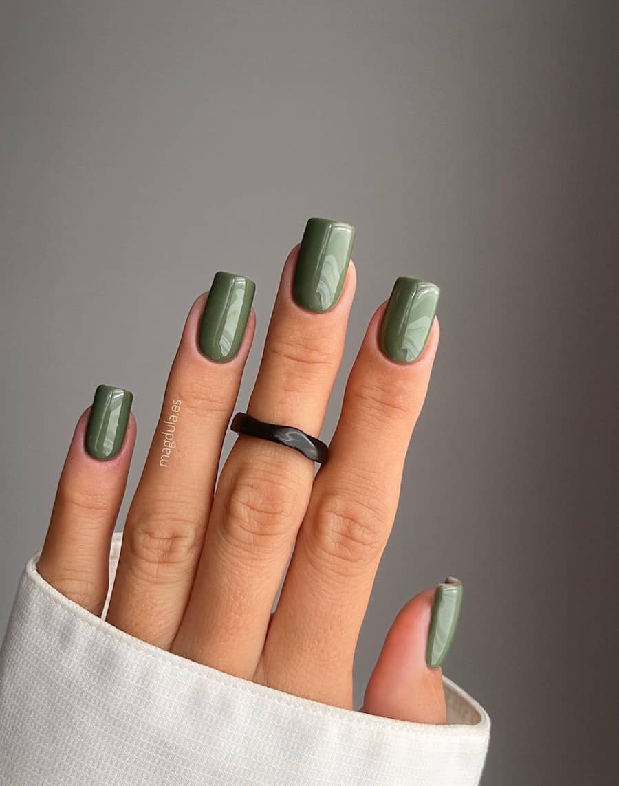 hand with square acrylic dark sage green polish nails