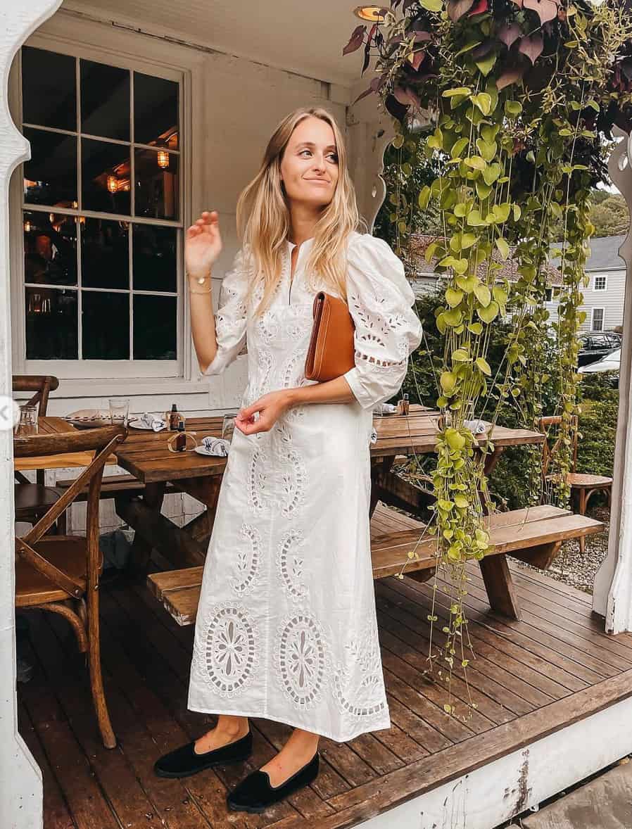 woman in a pretty lace midi dress with puff sleeves and black flats