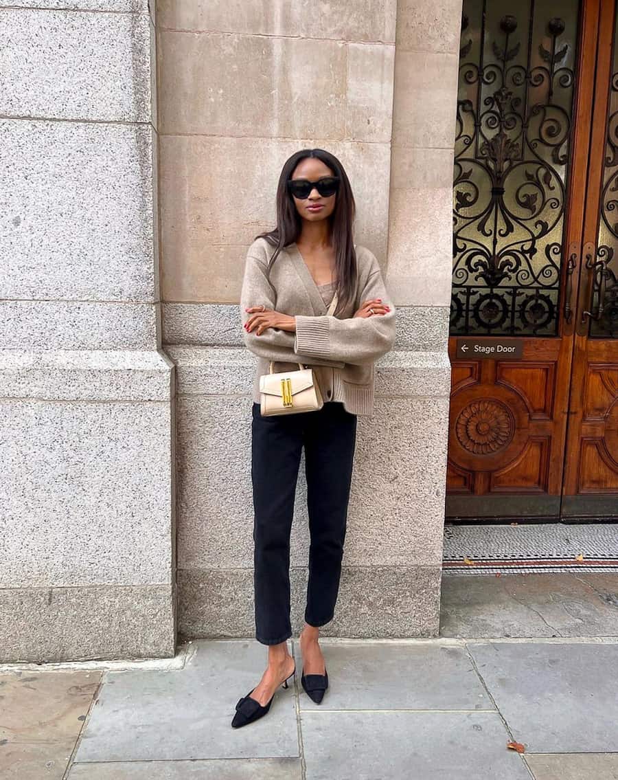 woman in a cardigan sweater, black skinny pants, and black flats