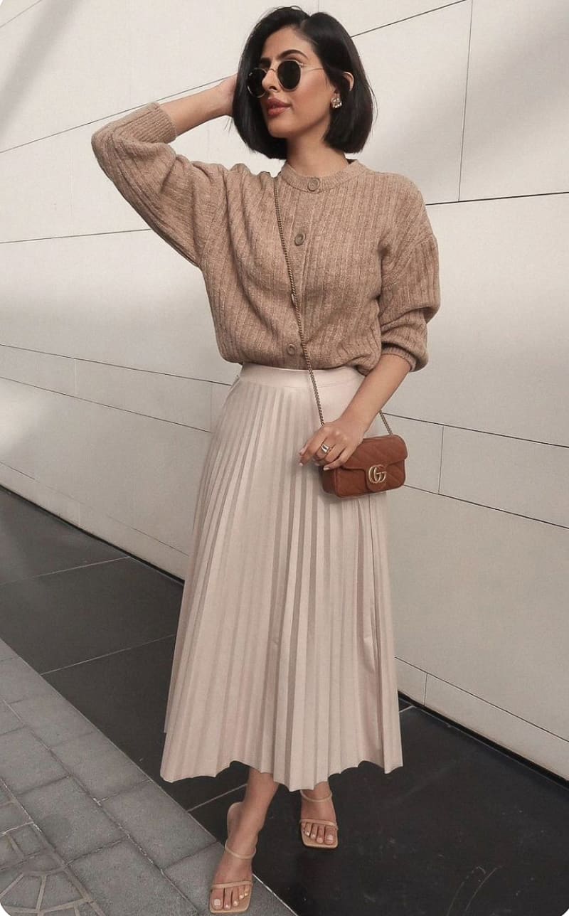 woman in a knit cardigan sweater, pleated midi skirt and heels