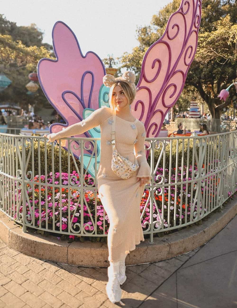 woman wearing a crochet midi dress with sneakers and Minnie Mouse ears at Disneyland
