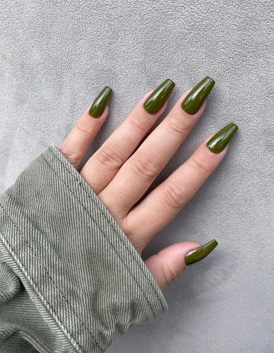 hand with coffin nails painted in olive green polish