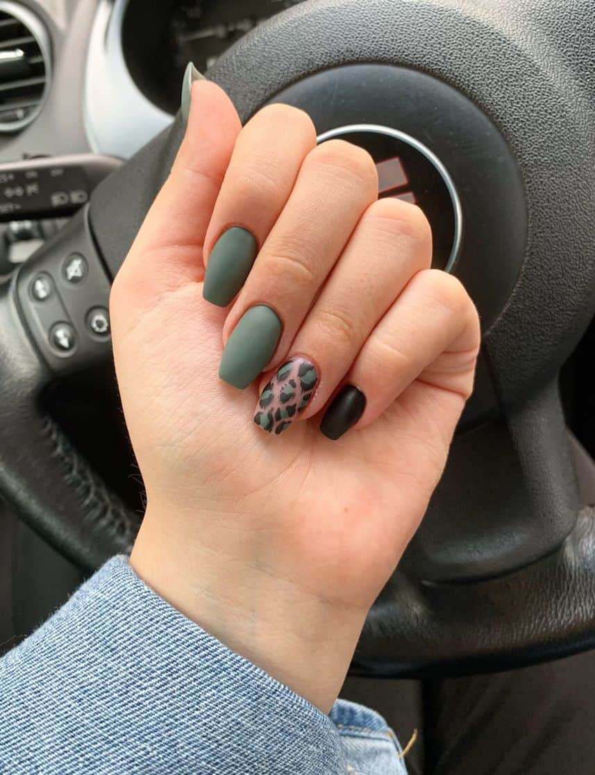 hand with short round nails with matte olive green and a leopard accent nail