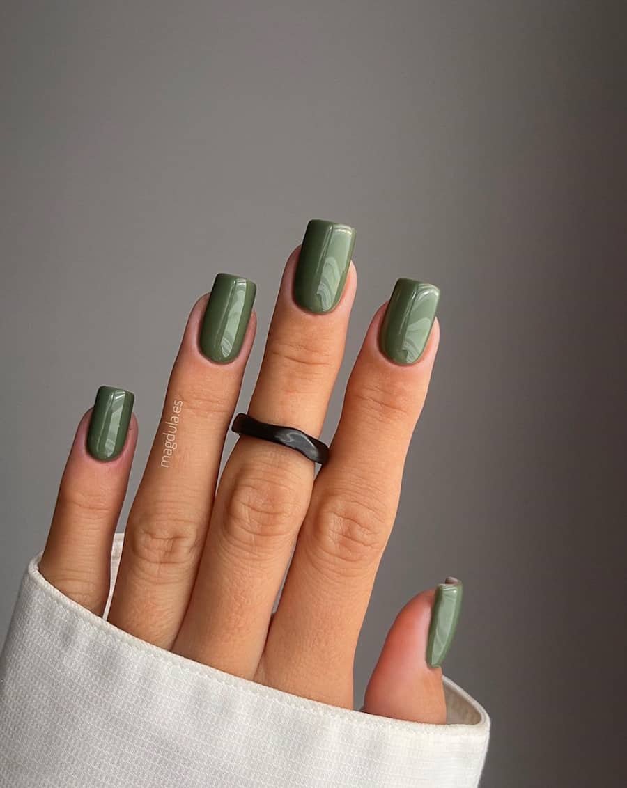 hand with square nails with olive green nail polish