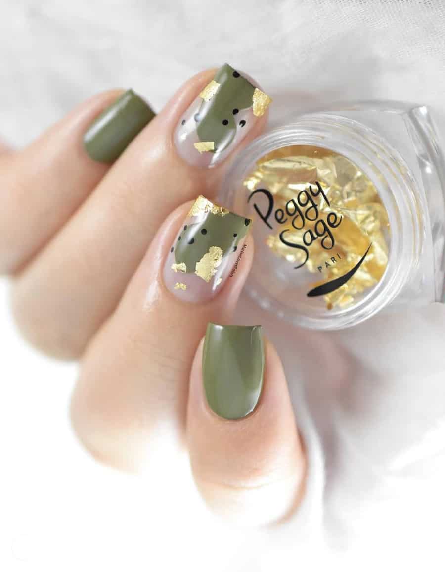 hand with short nails with olive green polish and gold foil accents