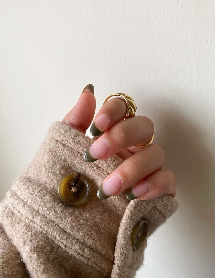 hand with olive green French tip nails