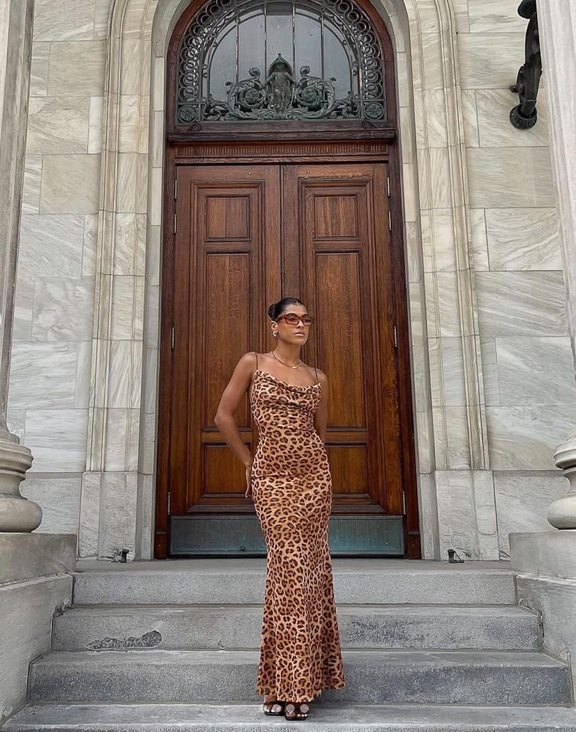 black woman wearing a sexy and classy leopard print maxi dress with heels