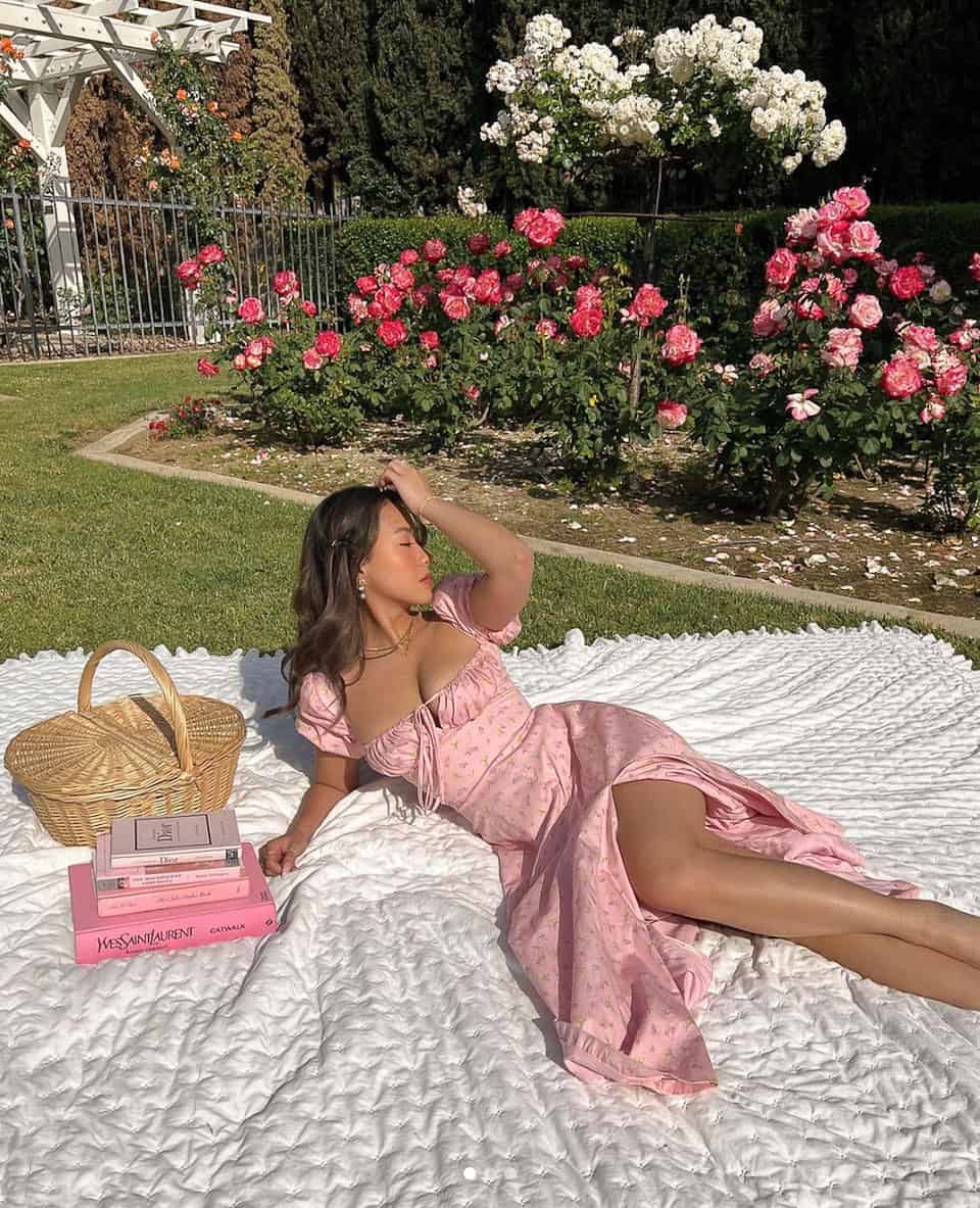 woman laying on a blanket in a garden in a pink floral bustier dress
