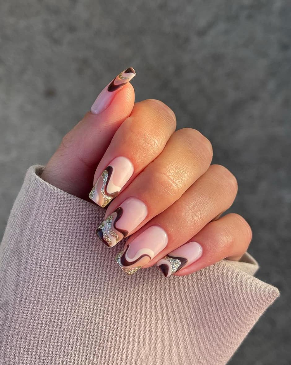 image of a hand with brown and cream wavy french tips