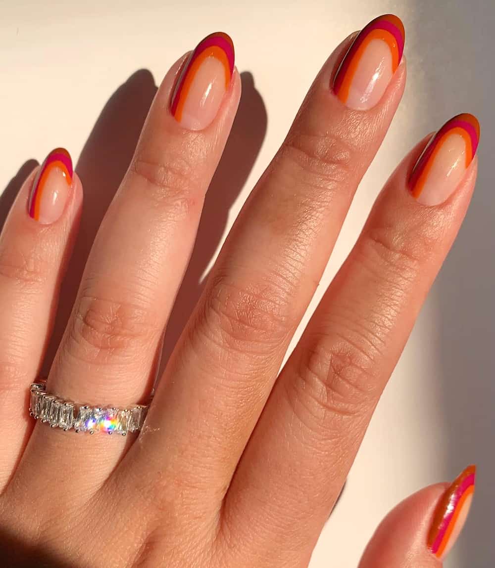image of a hand with brown, orange, and yellow rainbow retro nail art