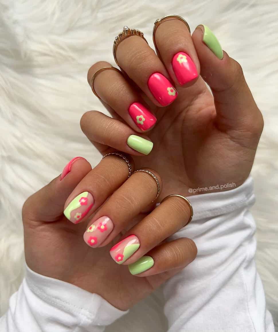 image of a hand with bright pink and green nails with retro daisy art