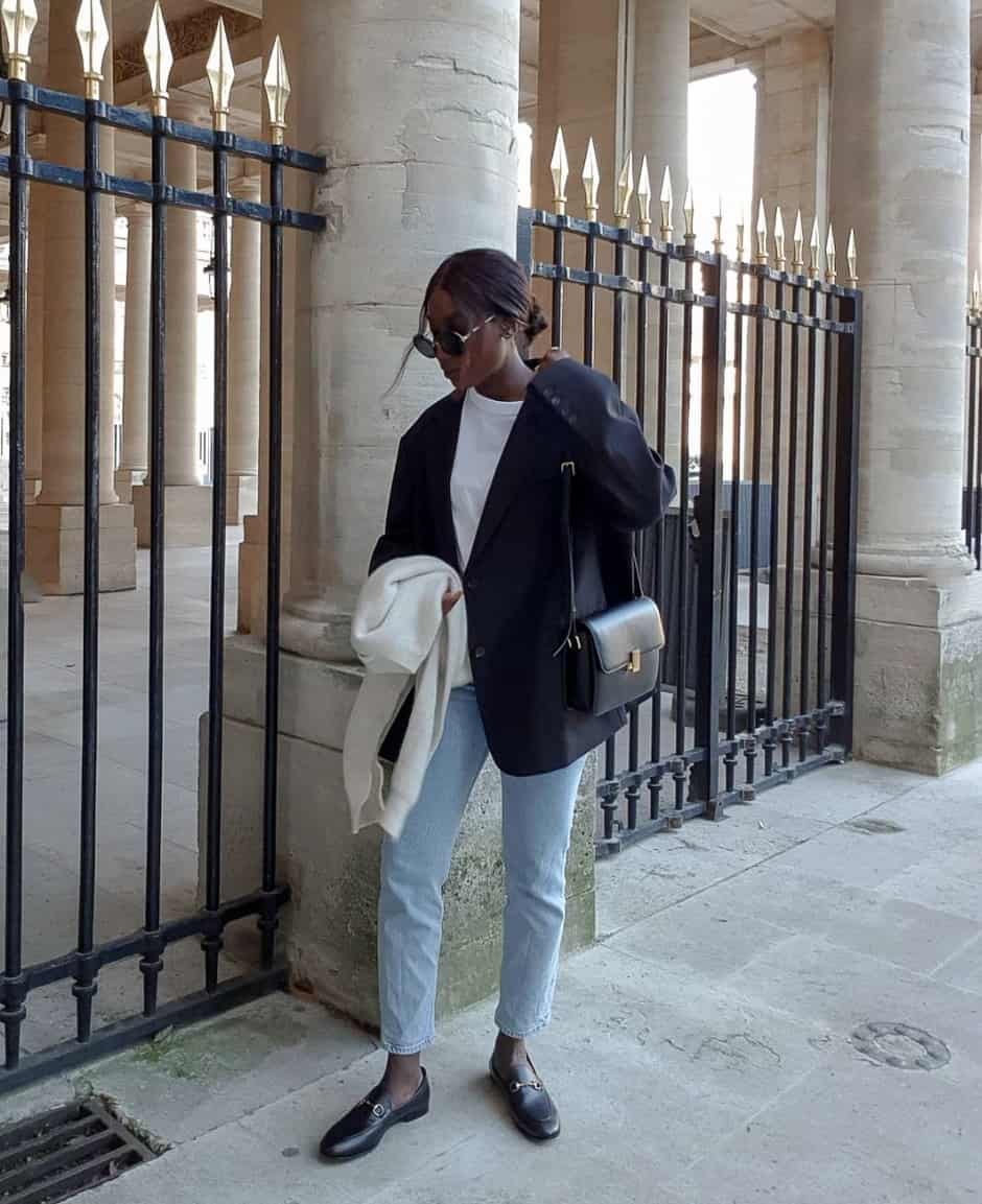 black woman wearing an oversized black blazer over a white t-shirt with light wash blue jeans and black horsebit loafers