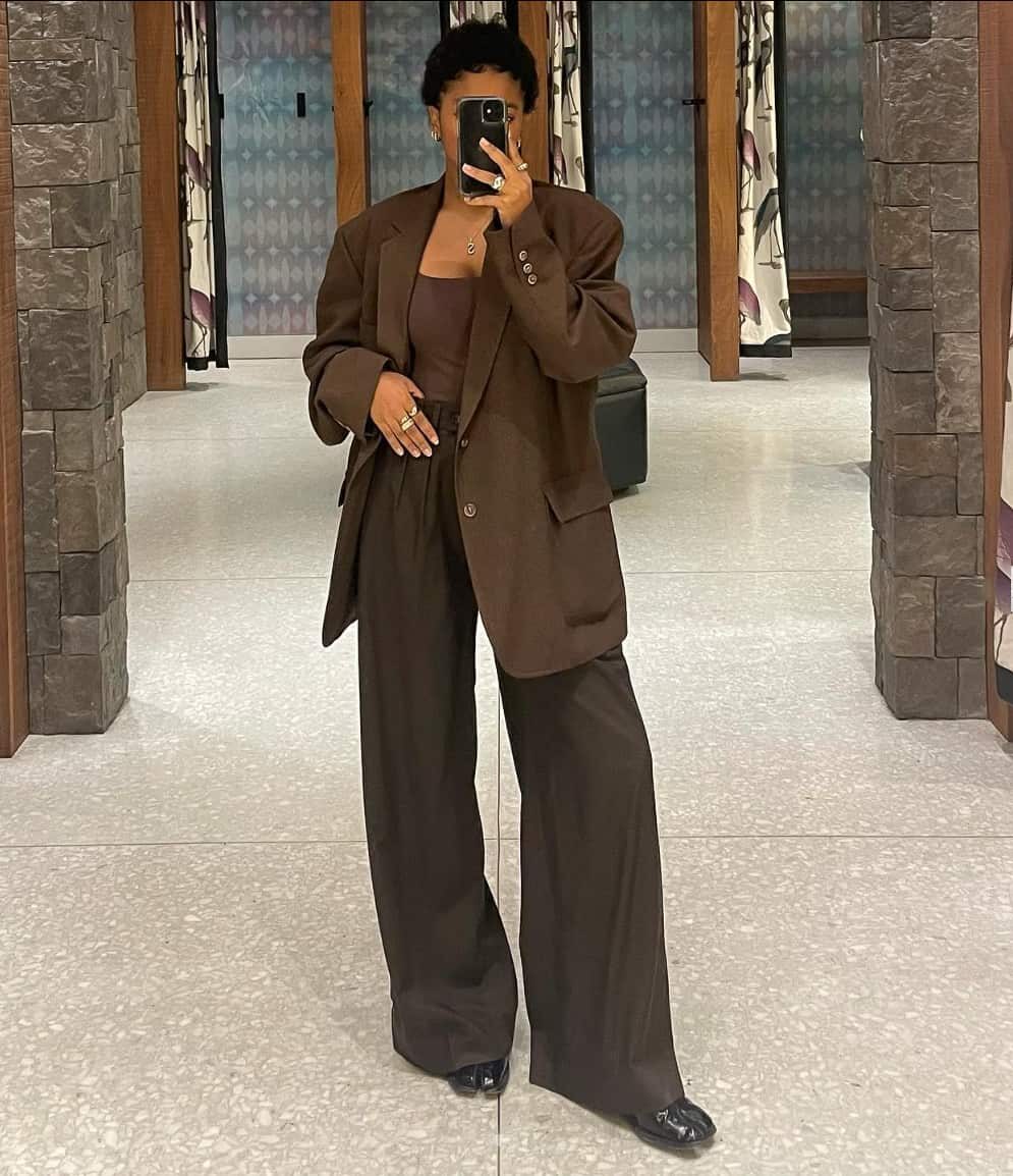 woman wearing an all brown outfit with an oversized blazer, tank top, and wide leg pants