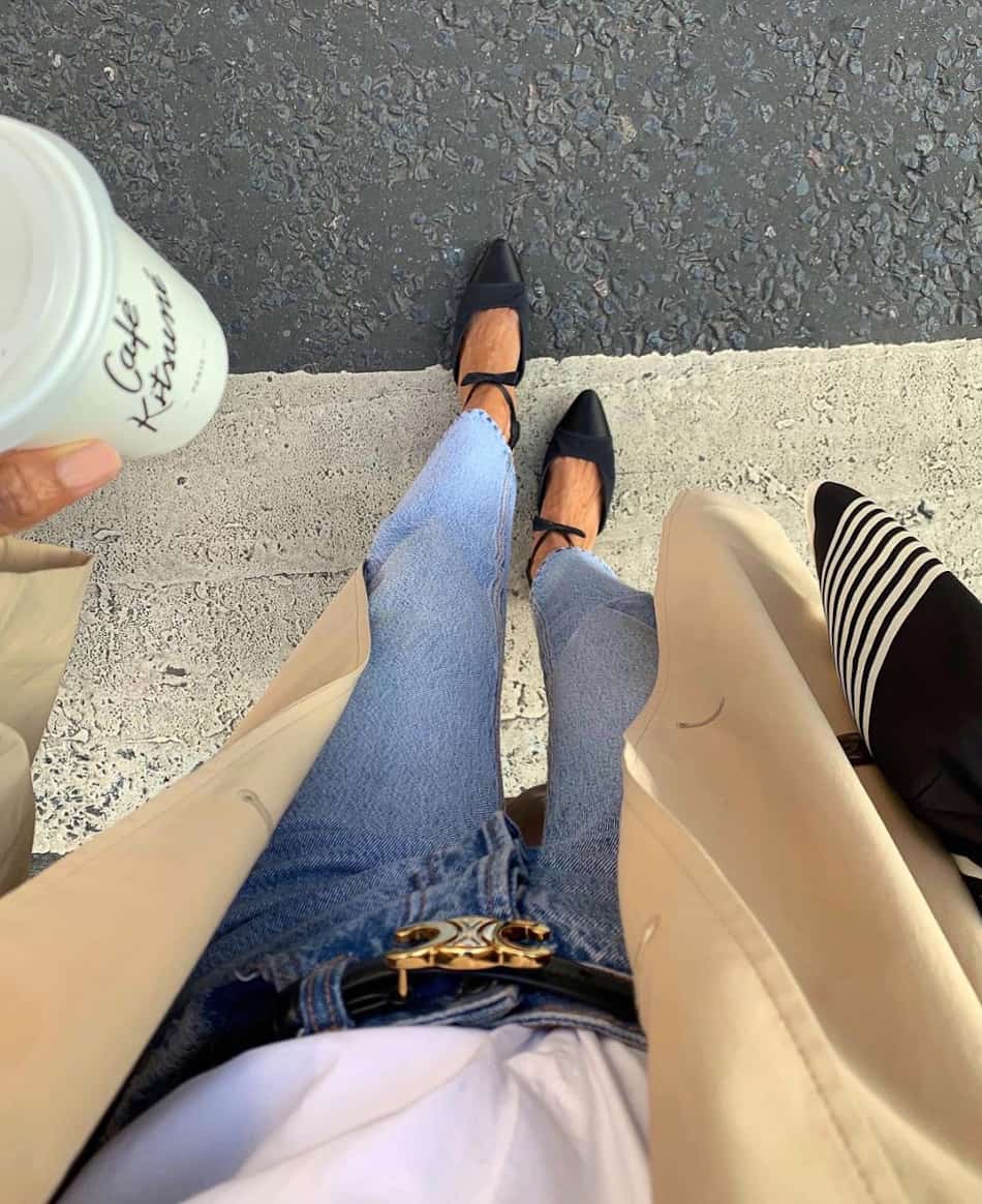overhead selfie of a woman in jeans and black heels with a Celine belt and tan trench coat
