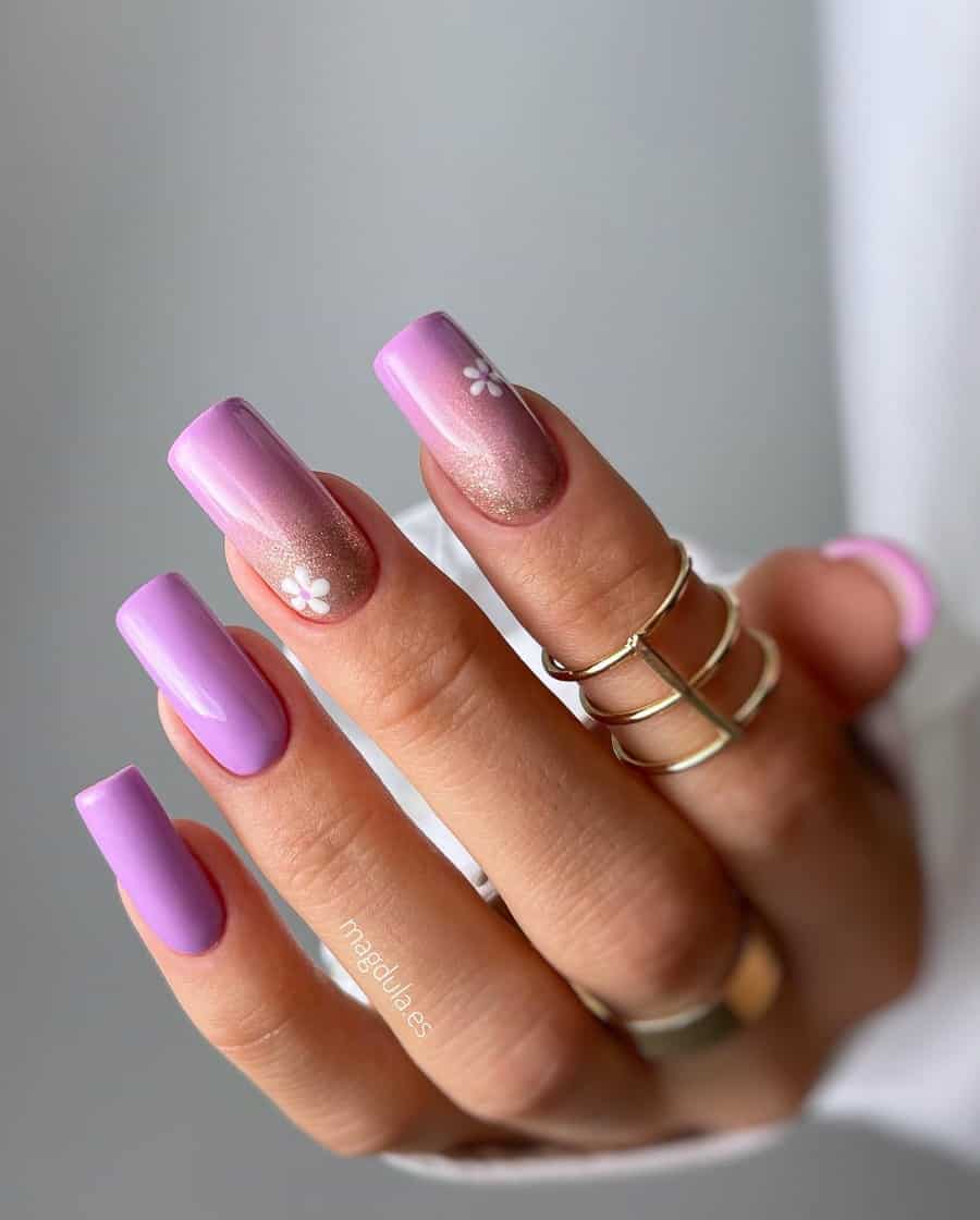 Long, square mauve manicure. Nails are bright purple mauve. Two nails have rose gold glitter and a daisy accent.