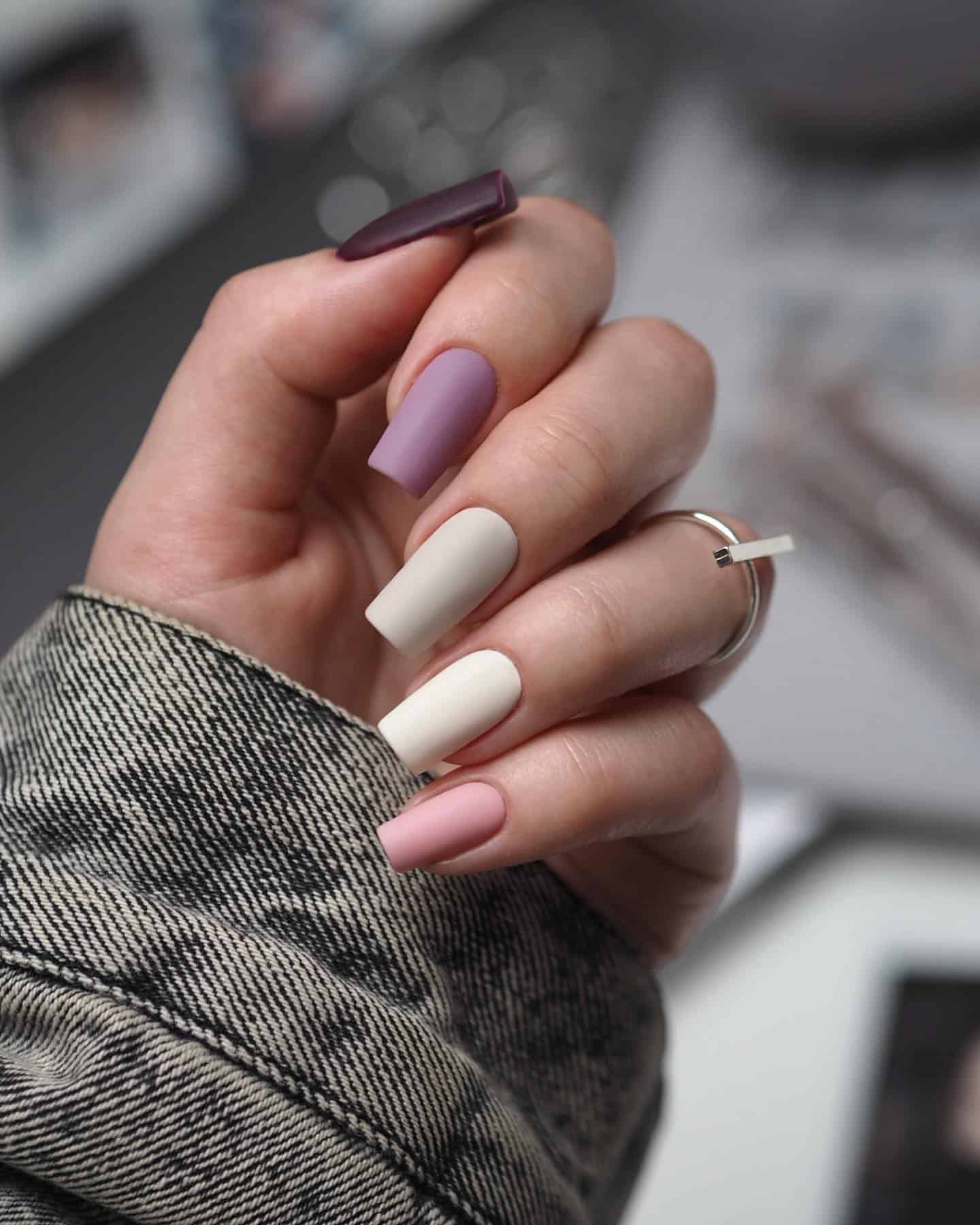 Long, square matte mauve gradient manicure. Three nails are different shades of mauve. Two nails are different shades of white.