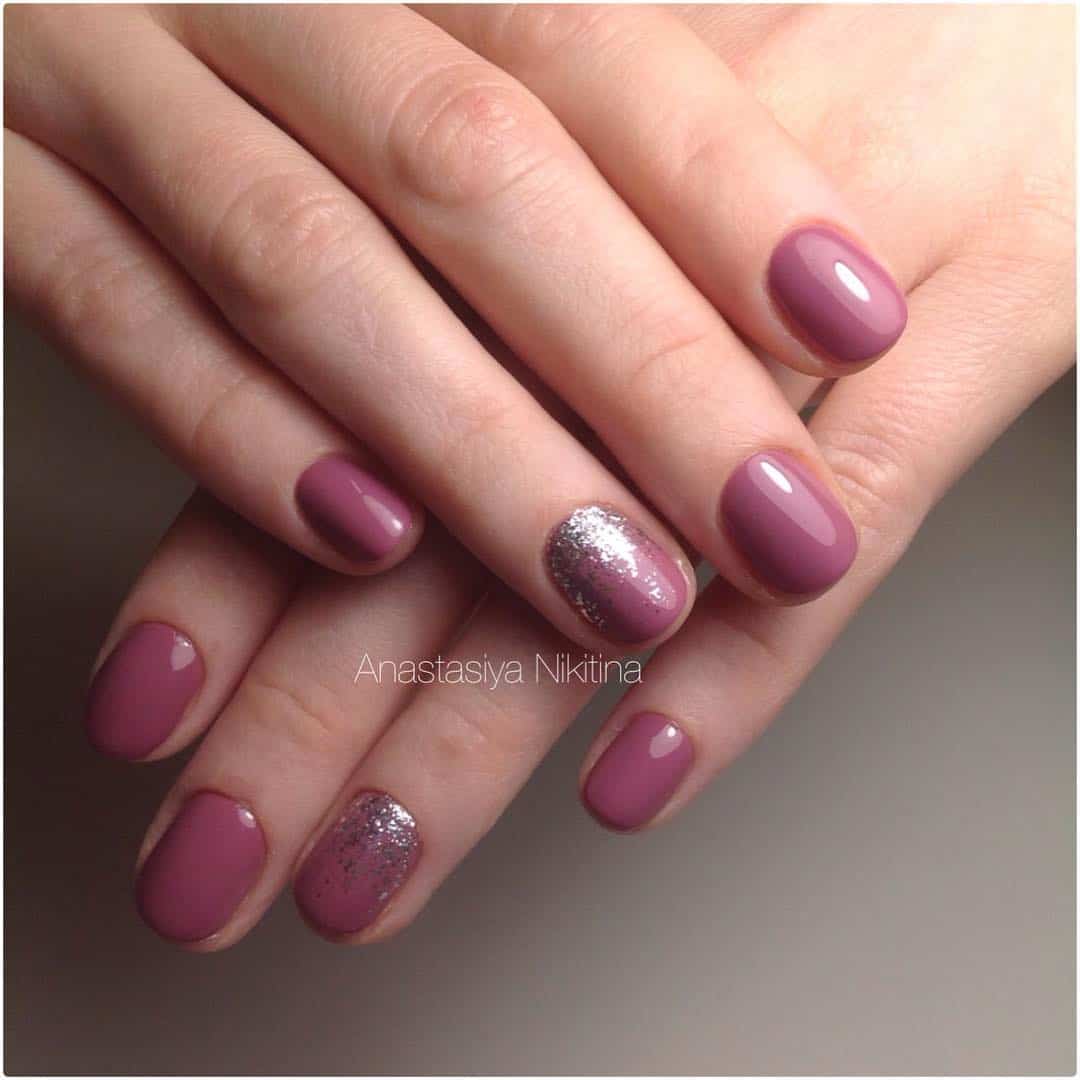Short purple mauve manicure with silver glitter on one nail on each hand.