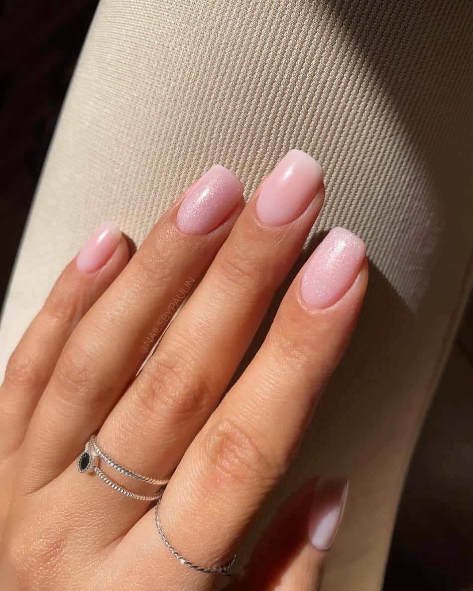 image of a hand with short gel nude pink ombre nails