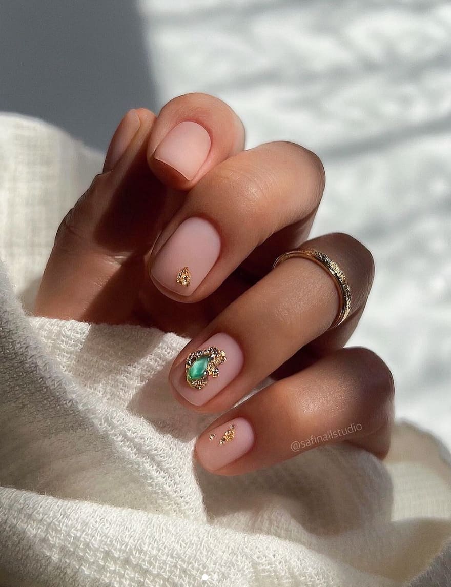 image of a hand with short natural nude nails with gem accents