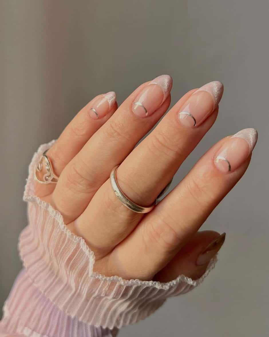 image of a hand with nude pink nails and shimmering french tips