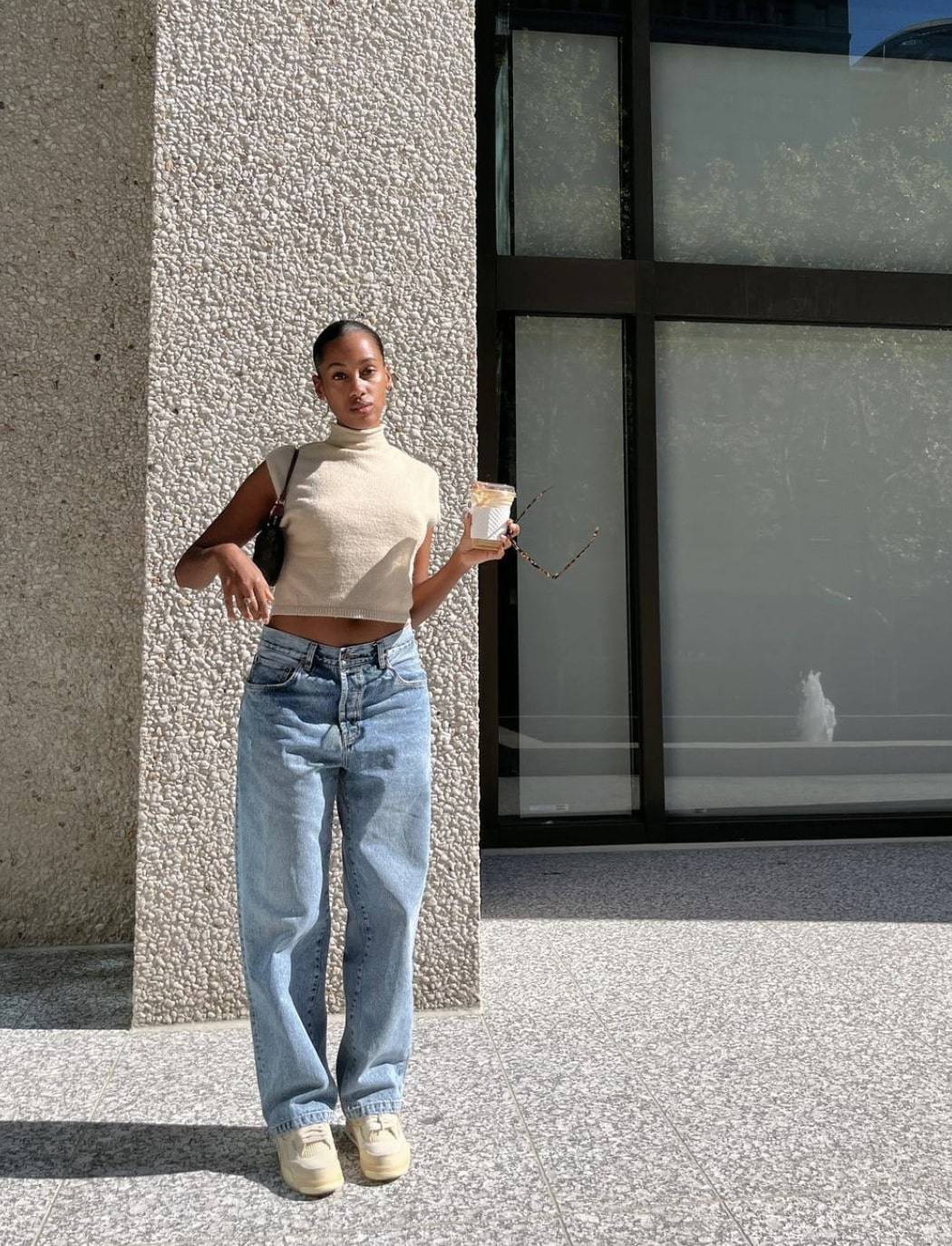 Black woman wearing a neutral top with loose dad jeans 