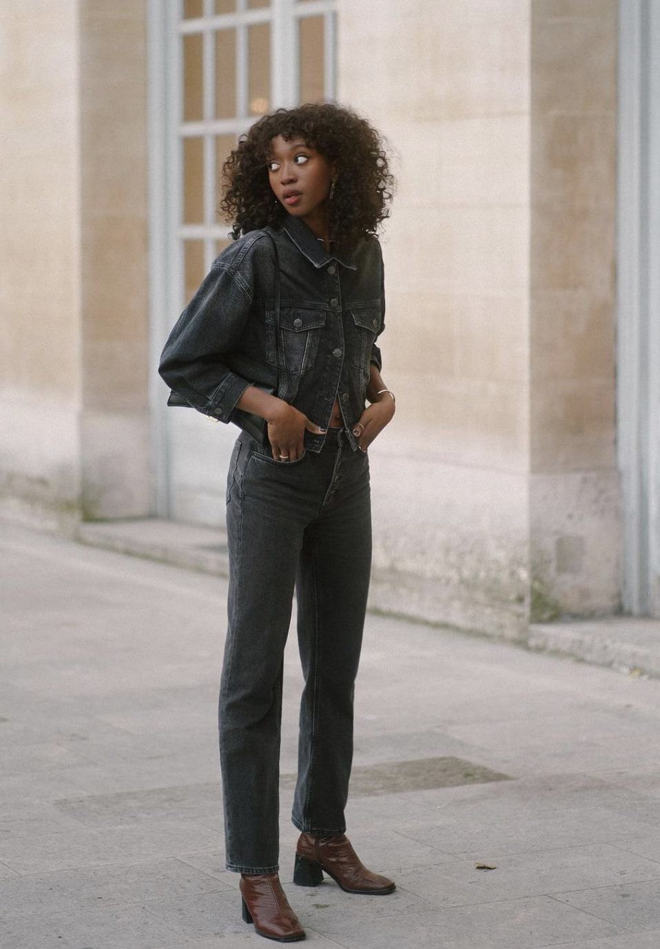 black french woman wearing a faded black denim jacket with faded black denim jeans and brown leather boots