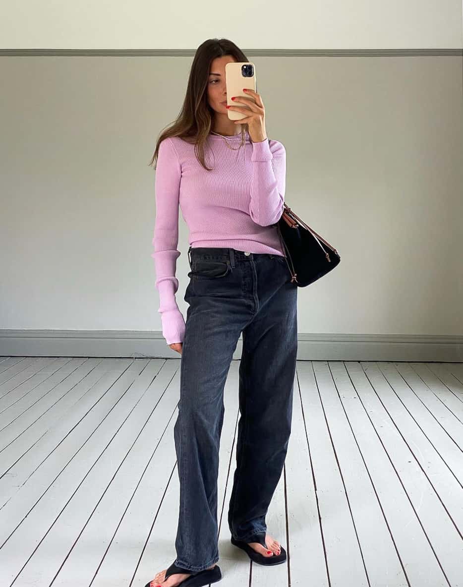 woman wearing a light pink knit sweater with black wide leg jeans and black sandals