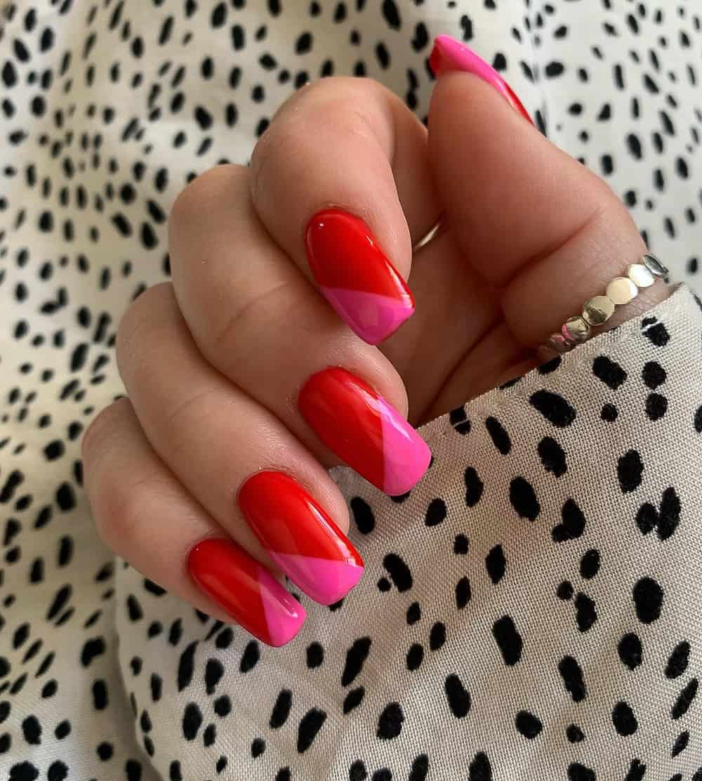 hand with square gel nails with pink and red colorblock design
