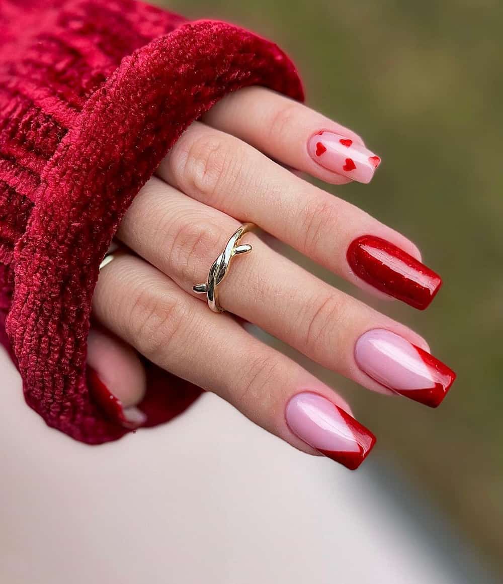 hand with long square naiils with shimmery pink and red french tips and accent nail