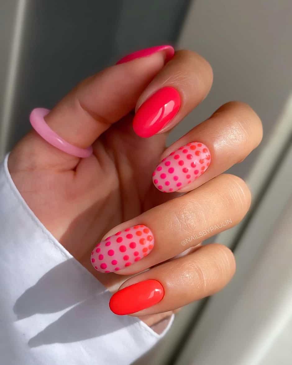 hand with almond nails with pink and red dot designs