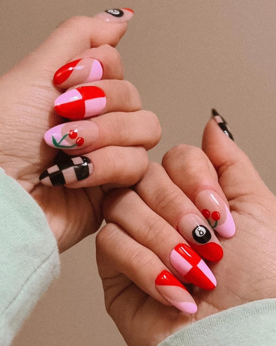 hand with pink and red checkered nails with black accents